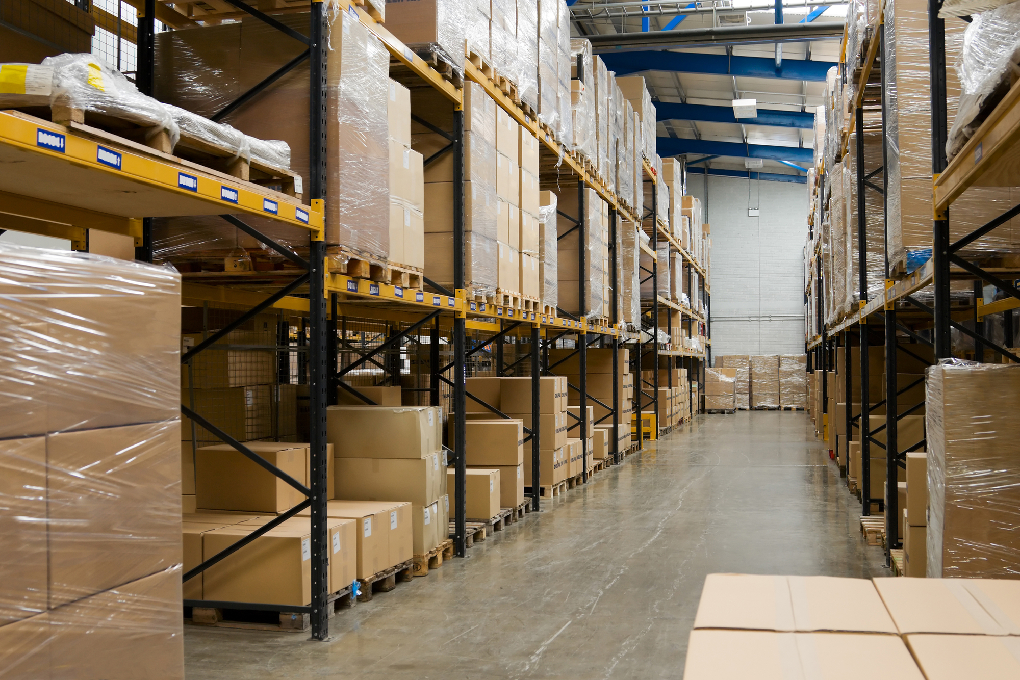 Industrial warehouse interior with shelves and pallets with cartons
